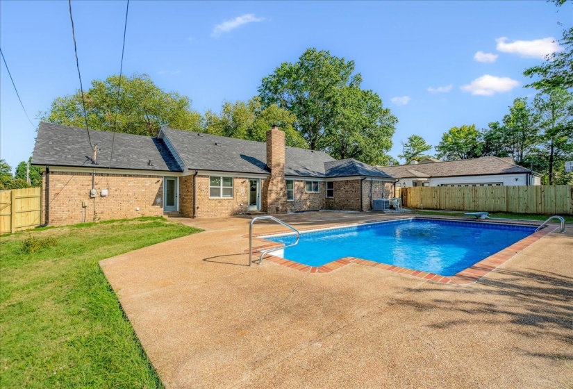 Rectangular in-ground pool with brick coping and concrete surround