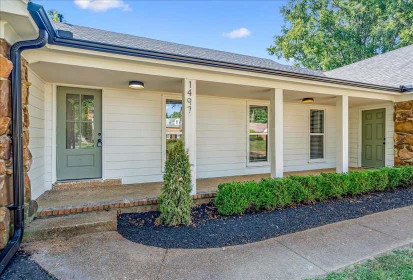 Covered front porch with white siding and stone accents