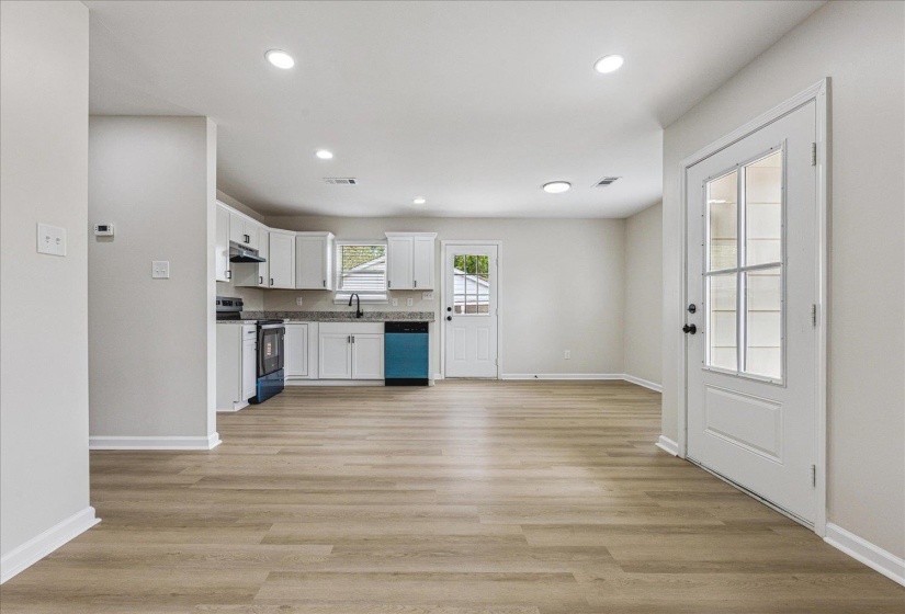 Open concept living area featuring wood-finish flooring, recessed lighting, and a modern kitchen
