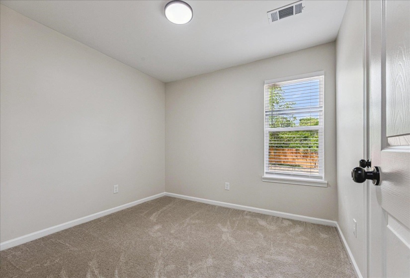 Neutral-toned interior room featuring light gray walls and plush carpet flooring
