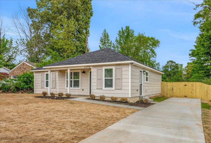 Single-story residence featuring light-colored siding, a dark shingle roof, and decorative window shutters