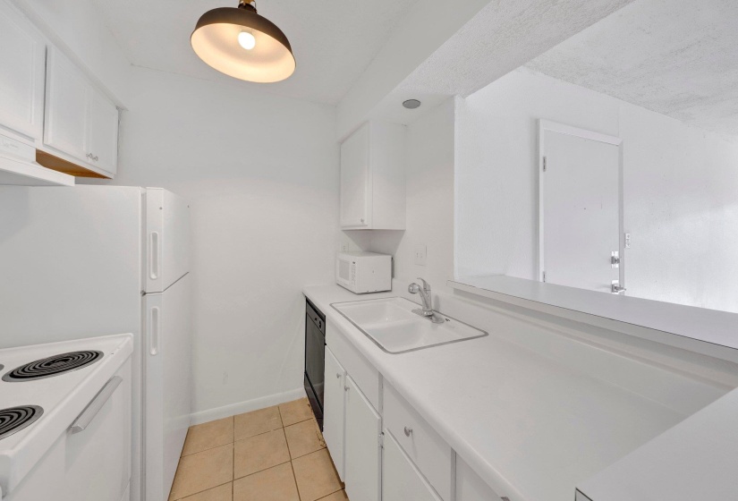 Kitchen featuring white cabinetry, white countertops, a double basin sink, and a black dishwasher