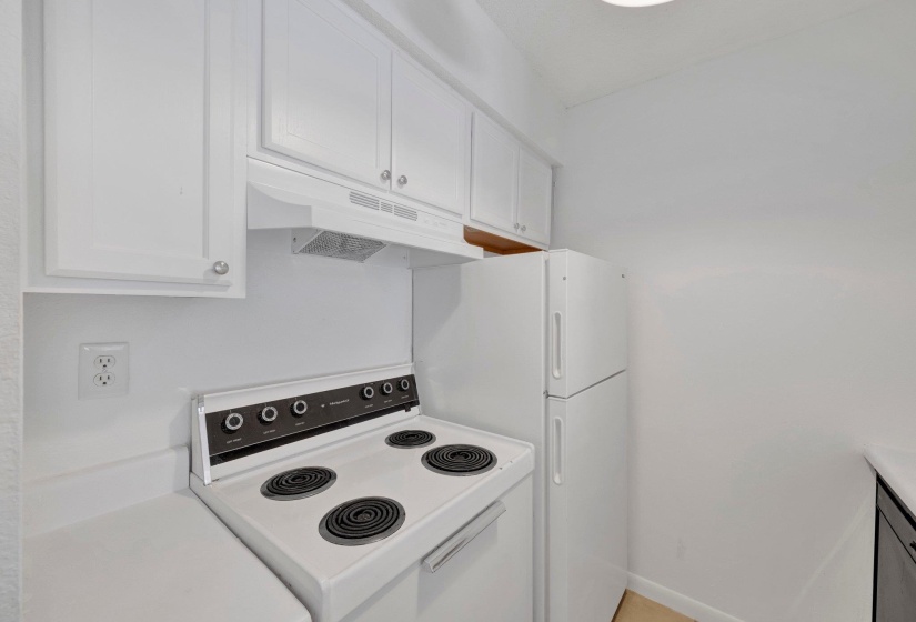 Bright kitchen featuring white cabinetry, a white electric range, and a white refrigerator