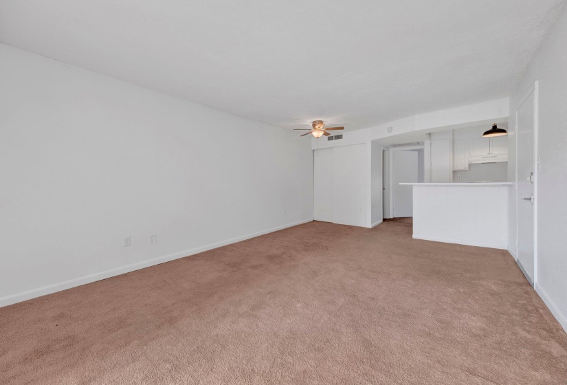 Spacious main living area featuring neutral carpet flooring and white walls