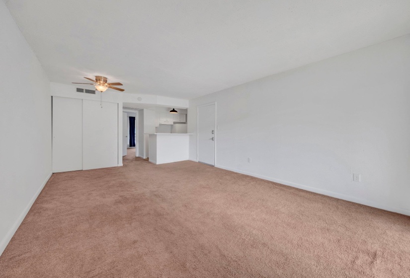 Expansive living area featuring neutral carpeting and white wall finishes
