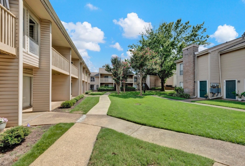 Exterior building features horizontal siding, individual balconies, and a partial brick chimney