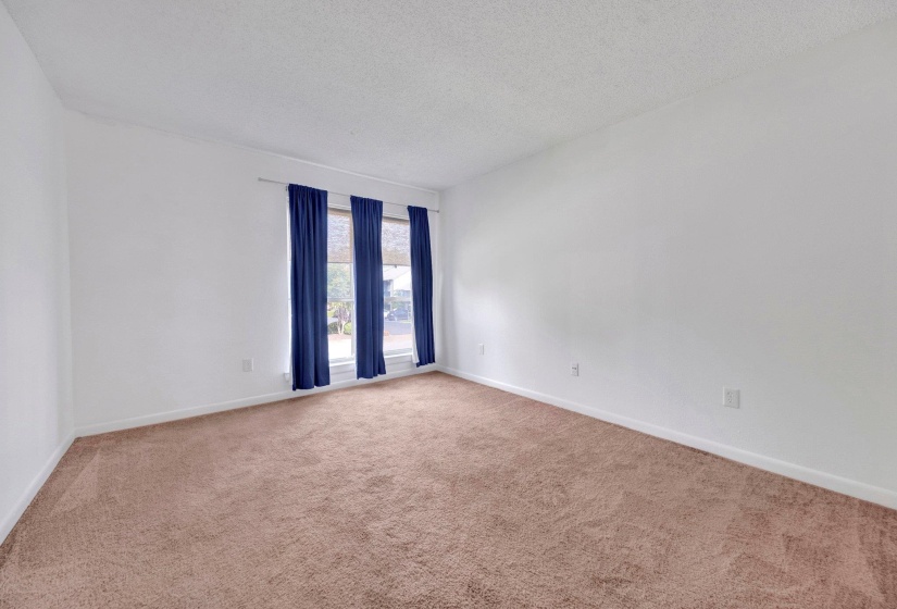 Room featuring neutral-toned carpet, white walls, and a window with vertical blinds