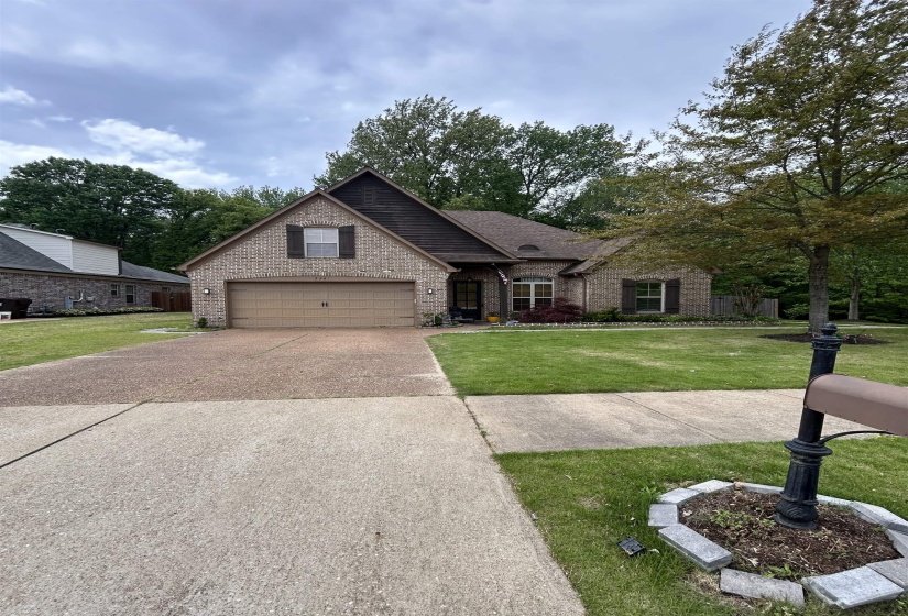 Brick facade residence featuring a front-facing attached garage, gabled roofline with dark shingles, and decorative window shutters