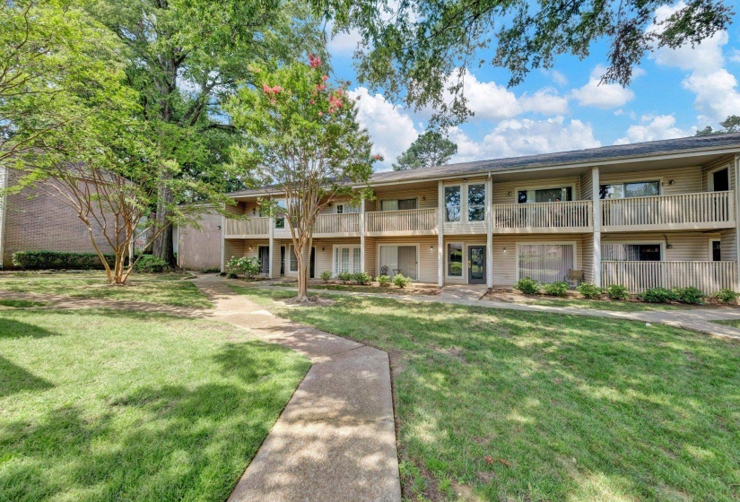 Two-story building exterior featuring vertical siding and private balconies on the upper level