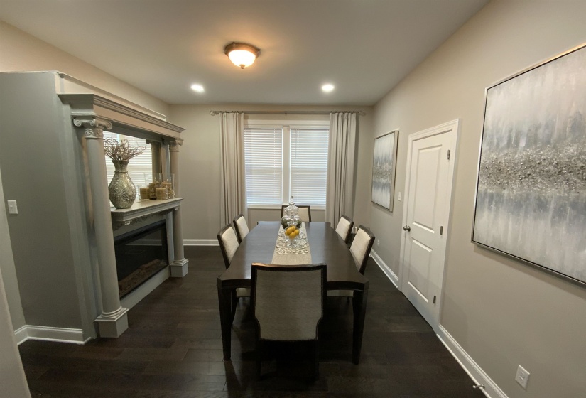 Formal dining area featuring dark wood-finish flooring and light neutral wall paint