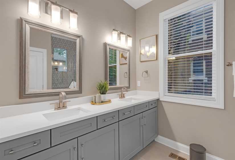 Full bathroom with double vanity, baseboards, and tile patterned flooring