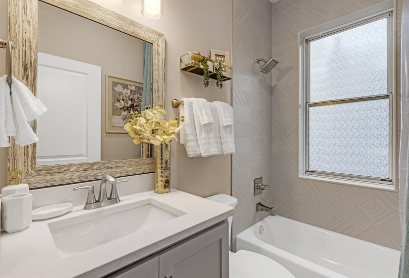 Bathroom with vanity, toilet, and shower / washtub combination