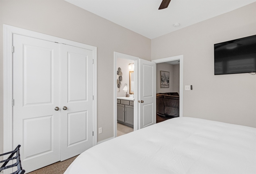 Bedroom featuring a closet, connected bathroom, and ceiling fan