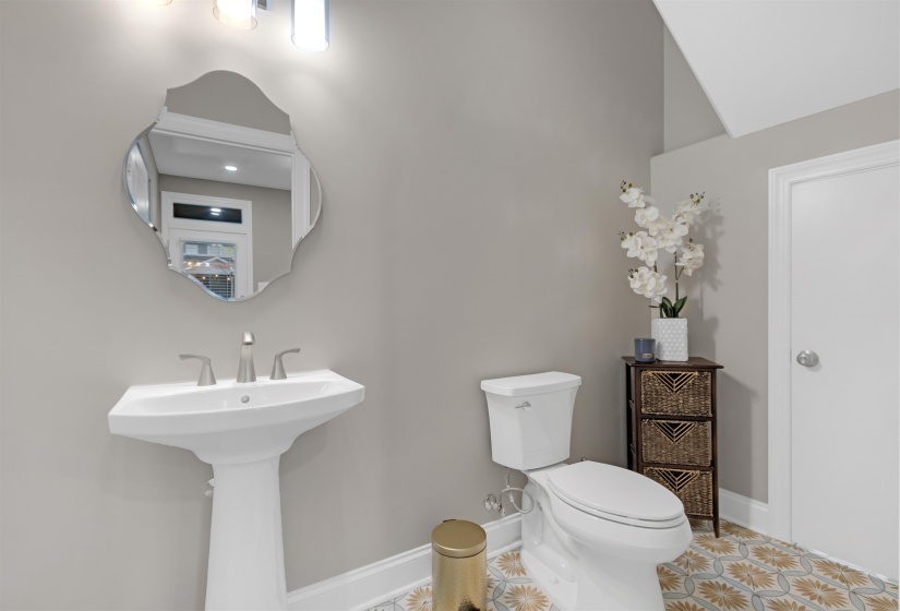 Half bath with toilet, tile patterned floors, and baseboards