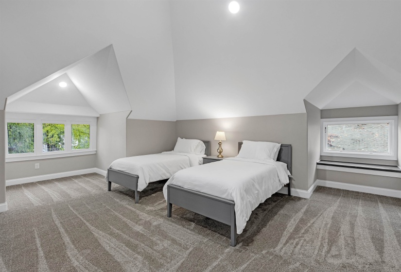 Carpeted bedroom featuring baseboards and lofted ceiling