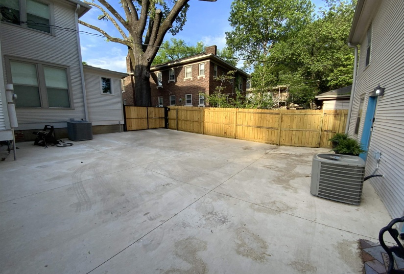 Spacious concrete patio area featuring a newly installed privacy fence, offering ample outdoor space