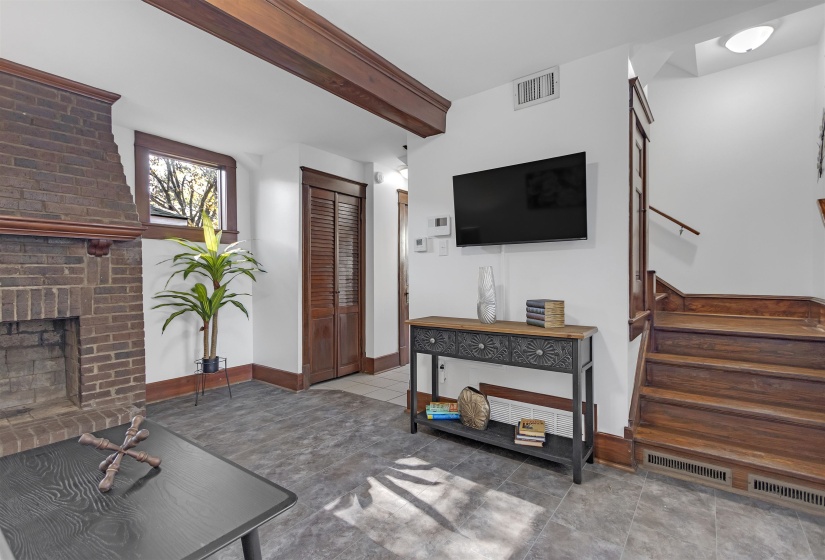 Living area with stairway, beam ceiling, a fireplace, and baseboards