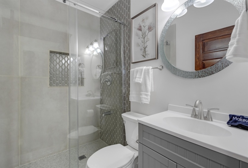Full bath featuring toilet, a stall shower, and vanity