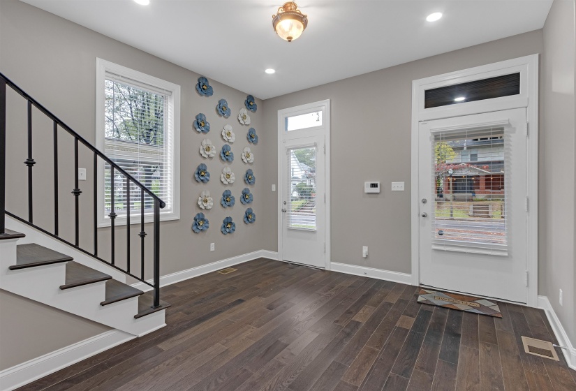 Foyer featuring wood finished floors, stairway, baseboards, and recessed lighting