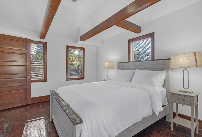 Bedroom featuring dark wood-style flooring, baseboards, and multiple windows