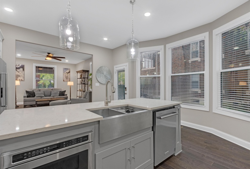 Kitchen featuring a sink, stainless steel dishwasher, light stone countertops, dark wood finished floors, and wall oven
