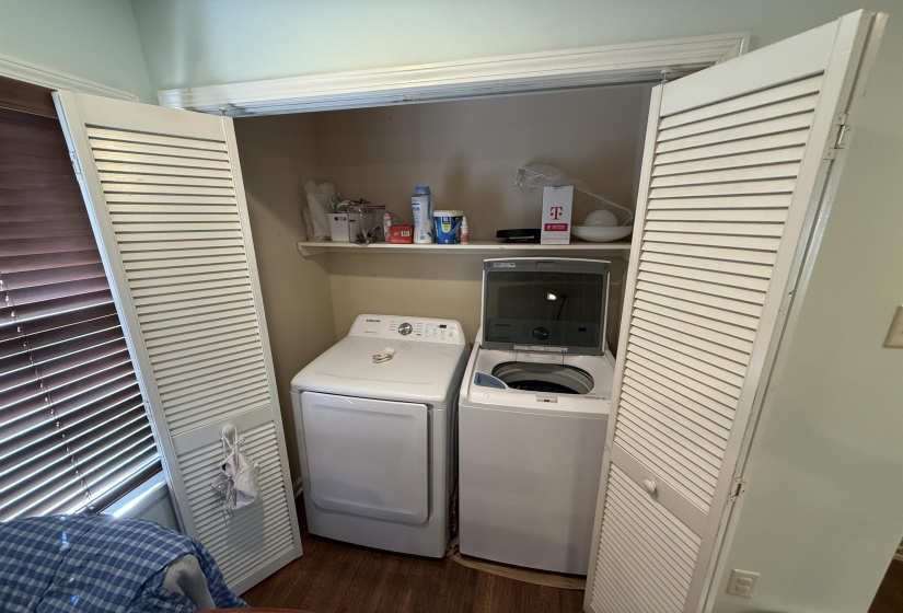 Laundry area featuring dark wood-type flooring and washing machine and clothes dryer