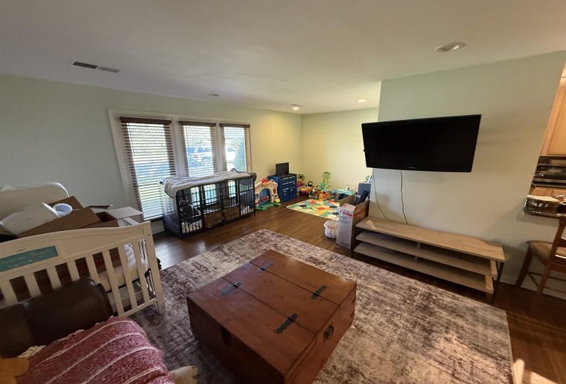 Living area with dark wood-type flooring and recessed lighting