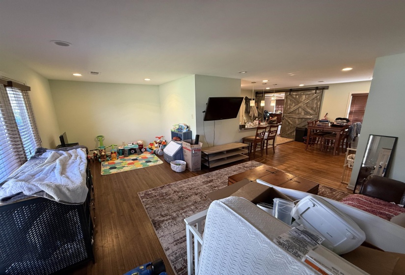Living area featuring a barn door, hardwood / wood-style floors, and recessed lighting