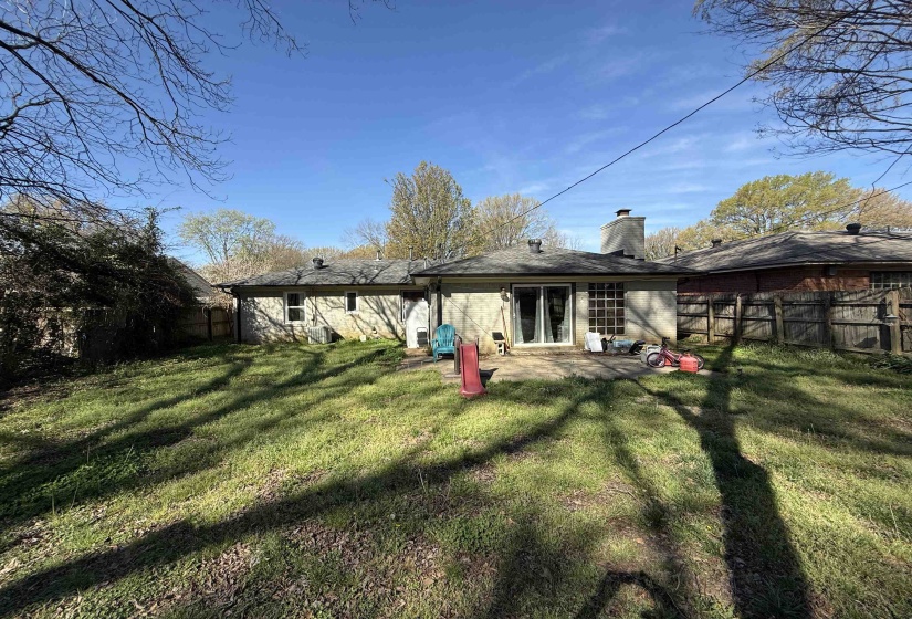 Rear view of property featuring a chimney, a fenced backyard, and a patio