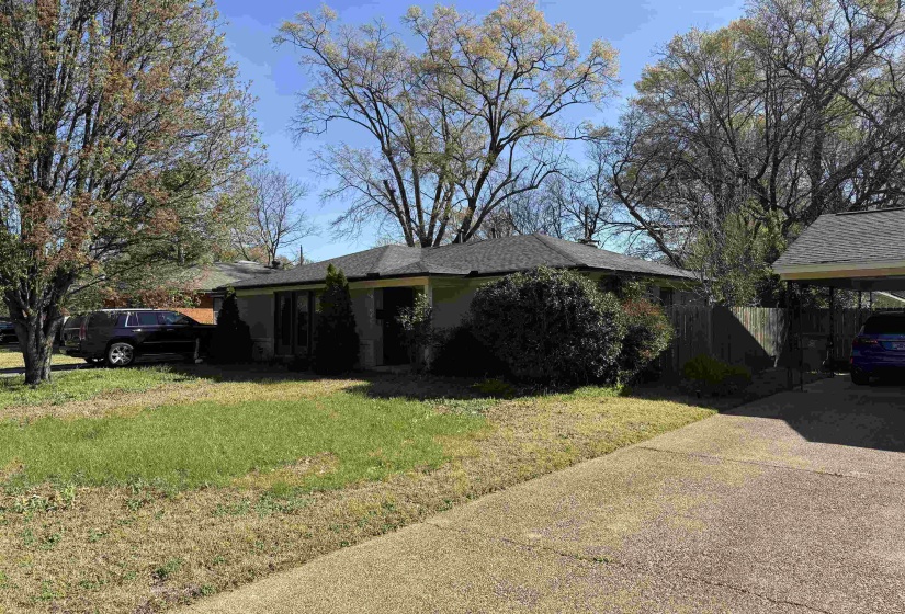 View of home's exterior with a shingled roof and driveway