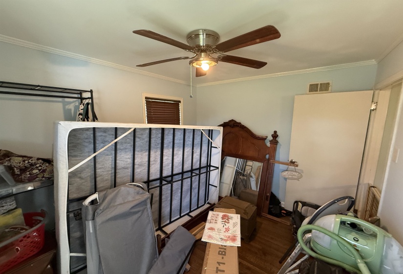 Bedroom with ornamental molding, a ceiling fan, and wood finished floors