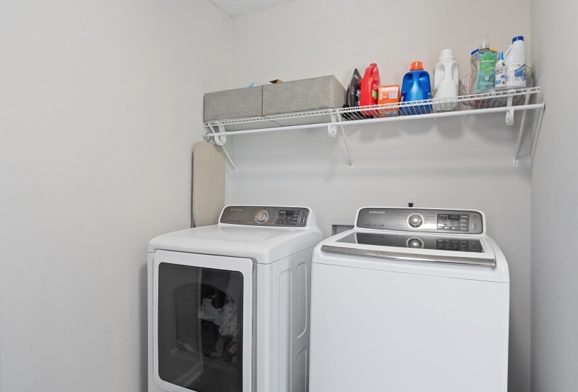 Dedicated laundry space featuring a white top-loading washing machine and a white front-loading dryer