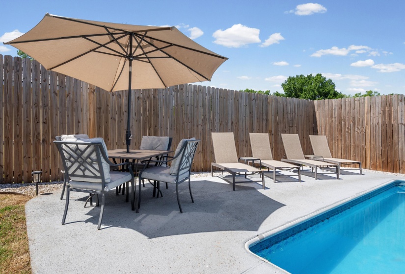 Inviting outdoor space featuring a rectangular swimming pool with a blue liner and concrete decking