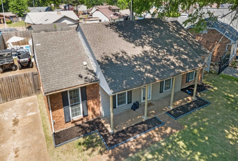Ranch-style residence featuring a brick and siding exterior, a covered front porch with columnar supports, a shingle roof, and mature landscaping beds