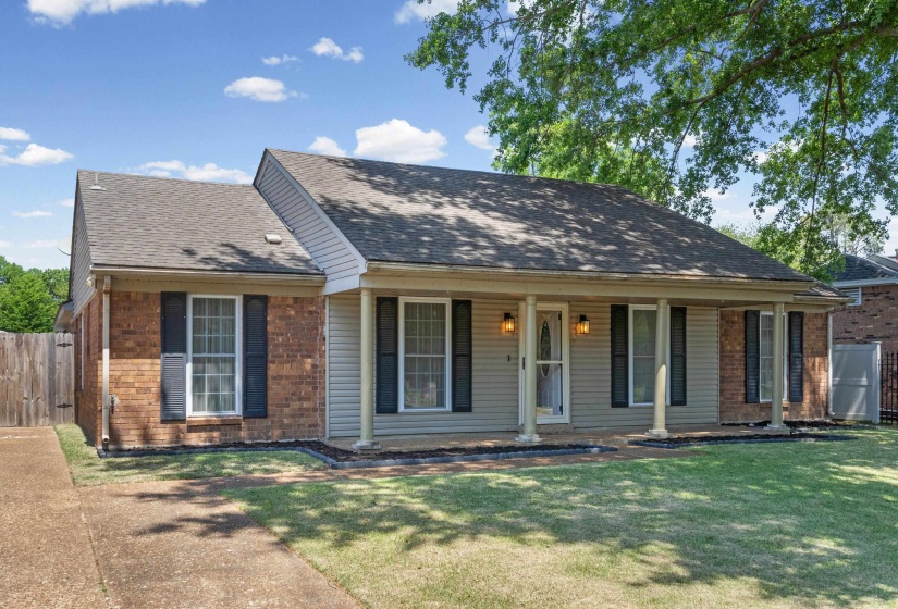Brick and siding exterior featuring a covered porch with white columns