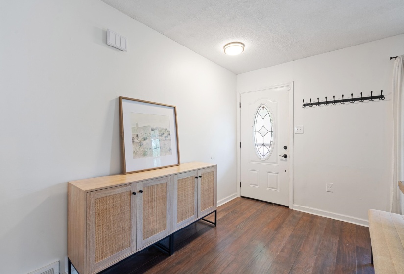 Entryway featuring a white door with an oval-shaped decorative glass insert, wood-finish flooring, and a flush-mount ceiling light