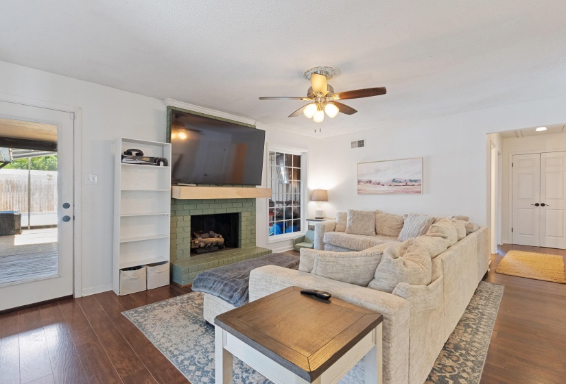 Living area featuring wood-finish flooring and a tiled fireplace with a mantel