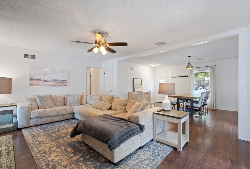 Open-concept living space featuring wood-finish flooring, recessed lighting, and a ceiling fan with integrated light fixture