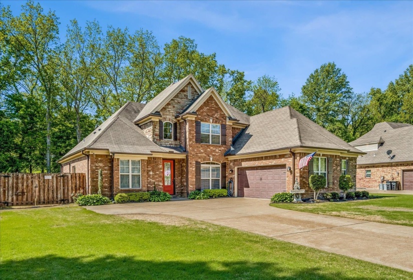 Traditional two-story brick and stone exterior with a prominent gabled roofline and multiple window styles