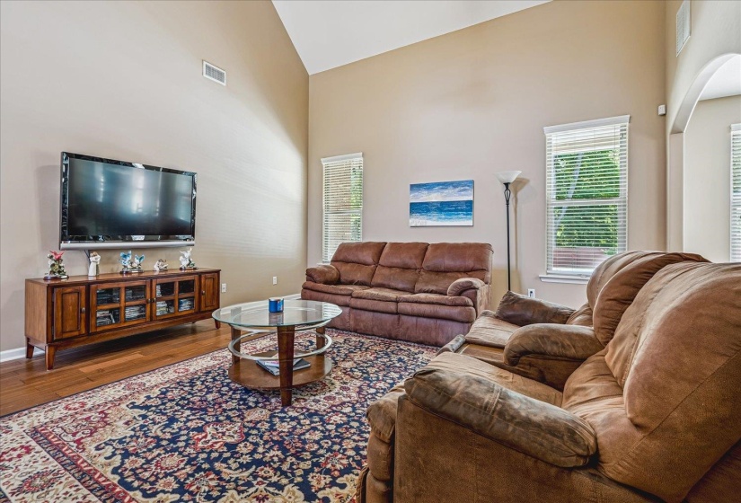 Vaulted Great Room featuring wood flooring, and multiple windows.