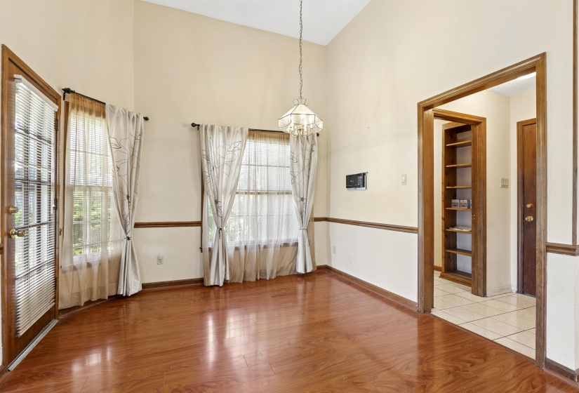 Room featuring vaulted ceilings, wood-finish flooring, and multiple windows
