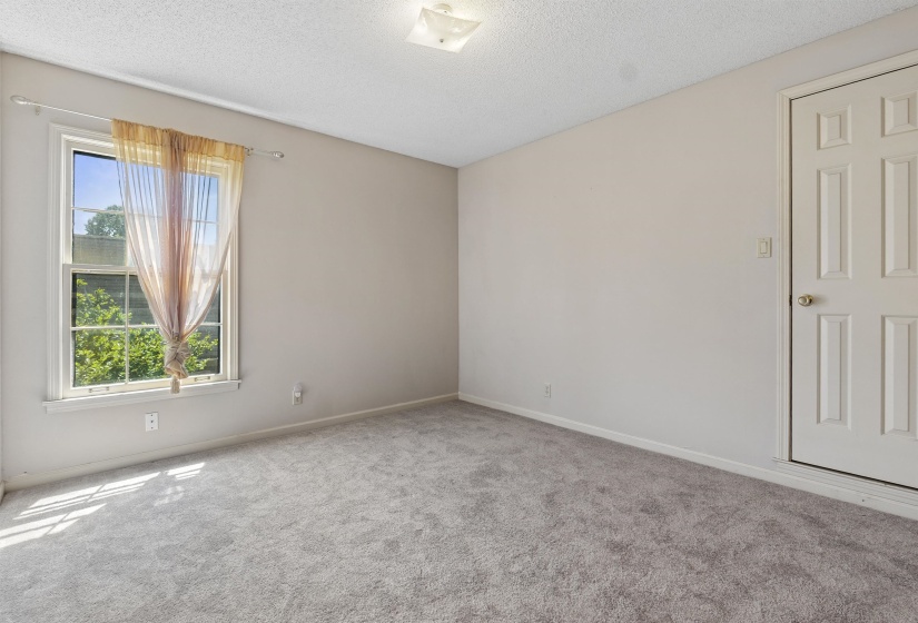 Neutral-toned room with light gray carpeting and white baseboards