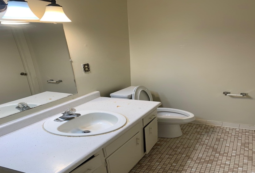 Bathroom with light tile patterned floors and vanity