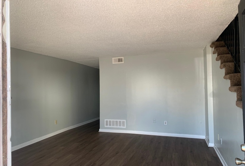 Empty room with dark wood-style floors and a textured ceiling