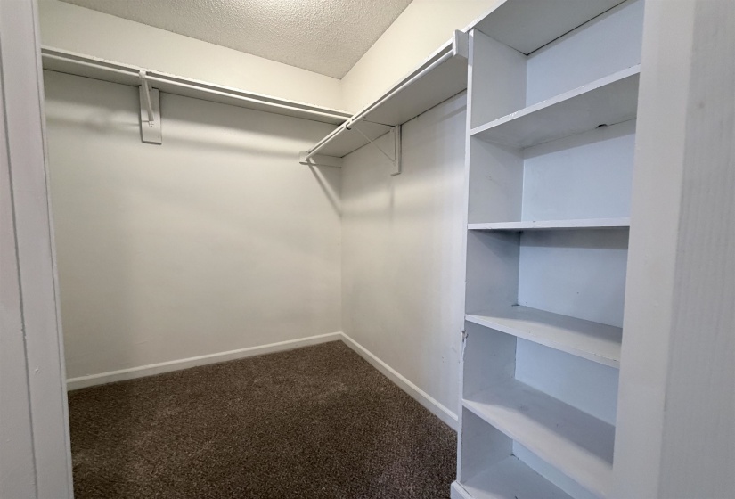 Walk in closet with dark carpet