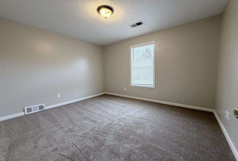 Unfurnished room featuring a textured ceiling and carpet flooring