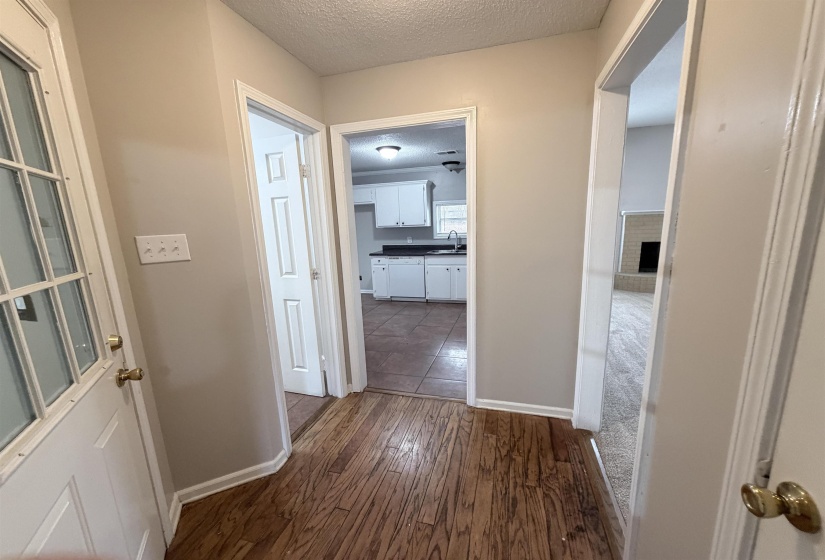 Corridor with a textured ceiling and dark wood-style flooring