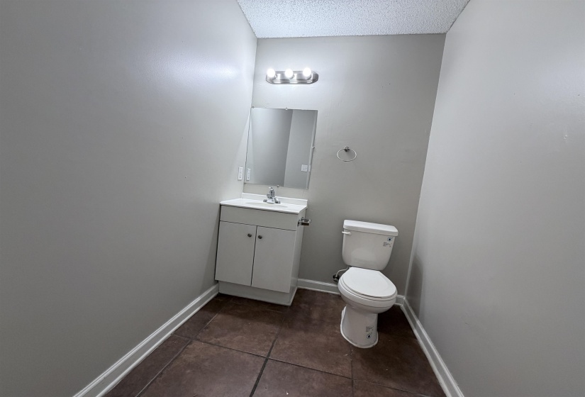 Bathroom featuring vanity, a textured ceiling, and dark tile patterned floors