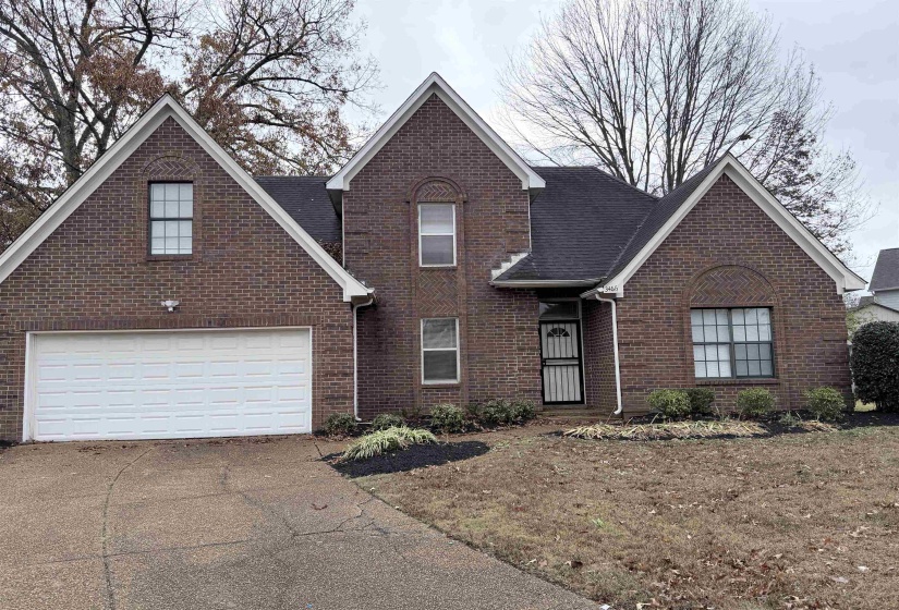 Traditional-style home with driveway and brick siding