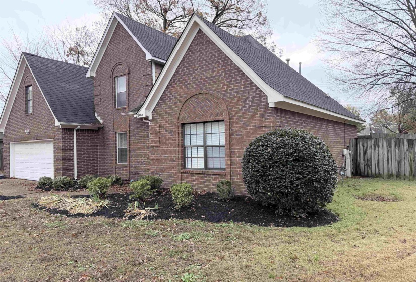 View of front of home featuring brick siding, a garage, and a shingled roof